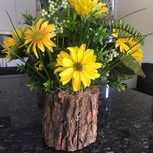 Faux yellow flowers in imitation wood vase